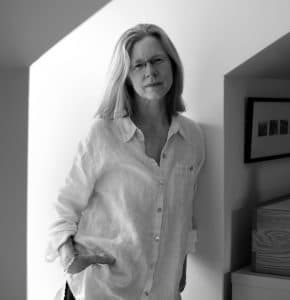 Environmental portrait of Lynn Johnson leaning against a wall.
